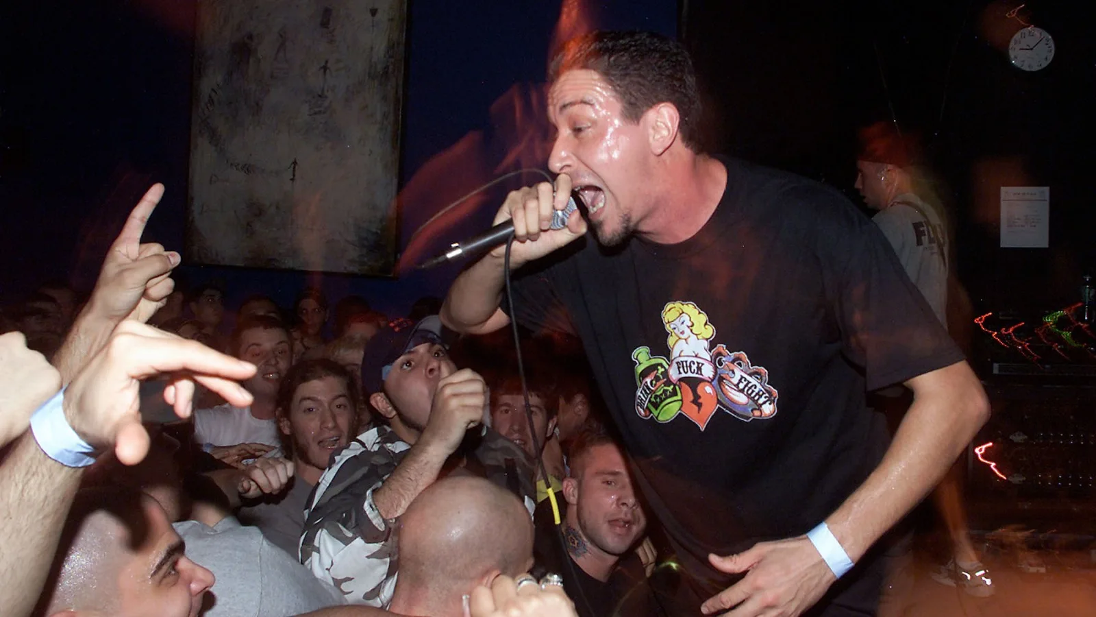 Lou Koller cantando con energía en un show de Sick of It All rodeado de fans